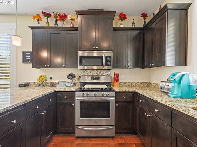 924 Park St, Sweet Home, OR 97386 - kitchen with light stone countertops, dark brown cabinets, appliances with stainless steel finishes, and dark wood finished floors