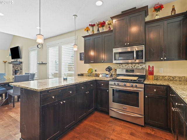 924 Park St, Sweet Home, OR 97386 - kitchen featuring a peninsula, appliances with stainless steel finishes, dark wood-style floors, and decorative backsplash