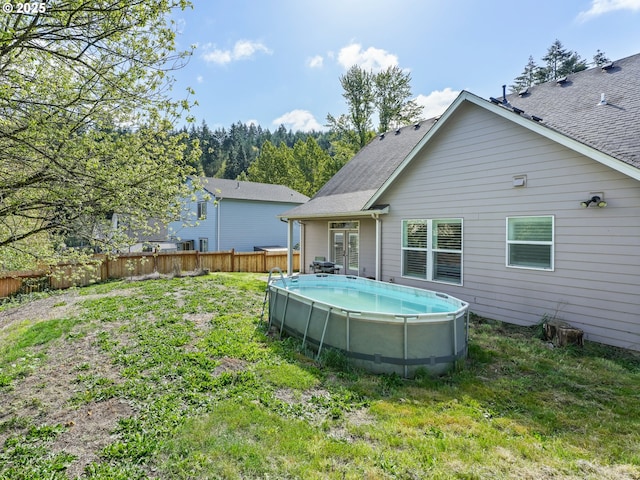 924 Park St, Sweet Home, OR 97386 - back of property with a yard, a fenced in pool, a shingled roof, and fence
