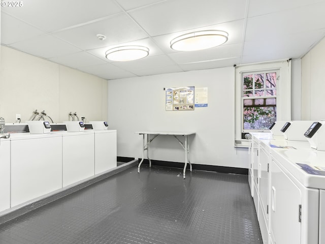 laundry area with dark tile patterned flooring and washing machine and dryer