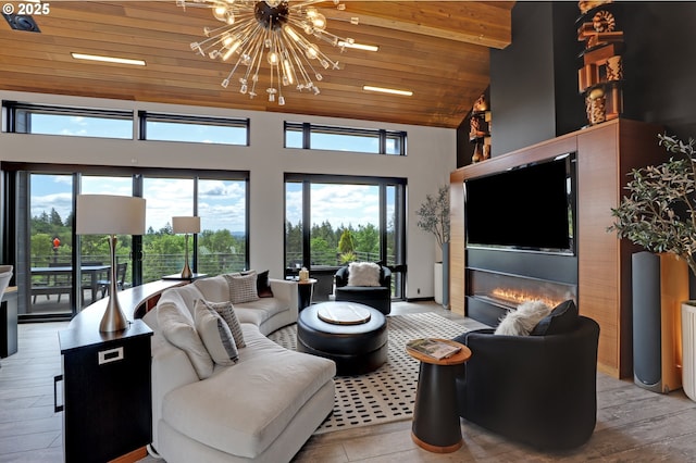 11440 NW Rock Creek Rd, Portland, OR 97231 - living room featuring wood ceiling, a chandelier, high vaulted ceiling, light wood-style floors, and a glass covered fireplace