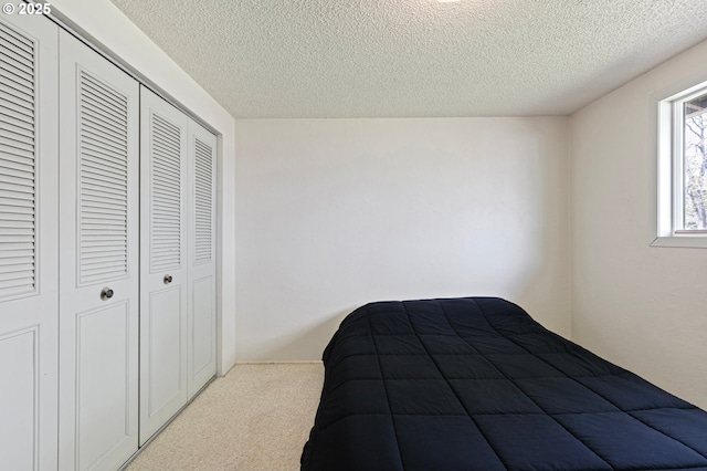 bedroom featuring carpet, a closet, and a textured ceiling