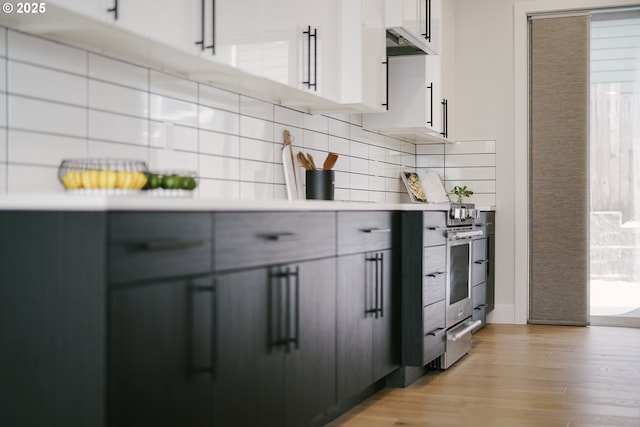 kitchen with white cabinetry, plenty of natural light, backsplash, and light wood-type flooring