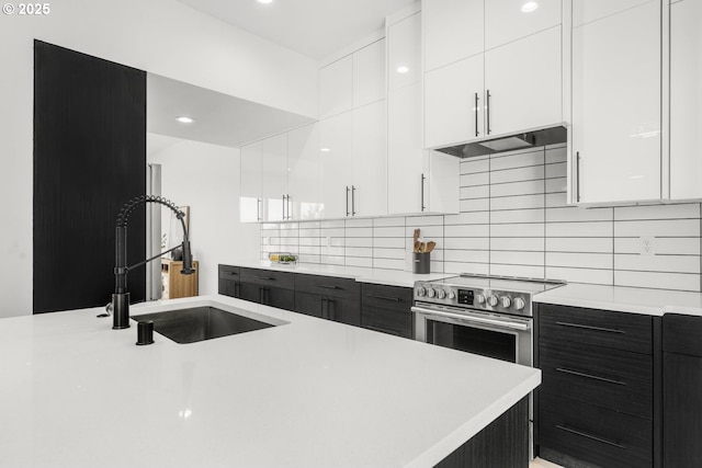 kitchen with sink, extractor fan, tasteful backsplash, stainless steel electric stove, and white cabinets