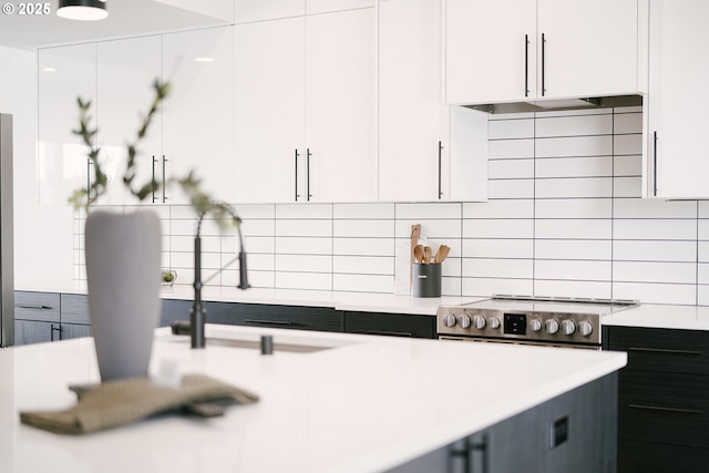 kitchen featuring white cabinetry, backsplash, sink, and exhaust hood