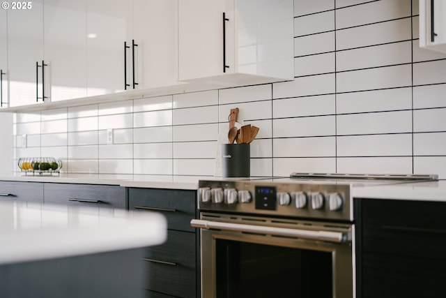 kitchen featuring electric stove, white cabinetry, and tasteful backsplash