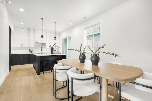 dining area with sink and light hardwood / wood-style flooring