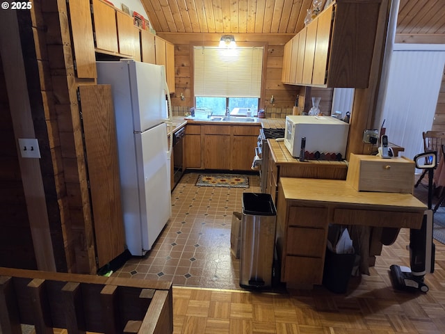 kitchen with white appliances, wooden walls, wood ceiling, and brown cabinets