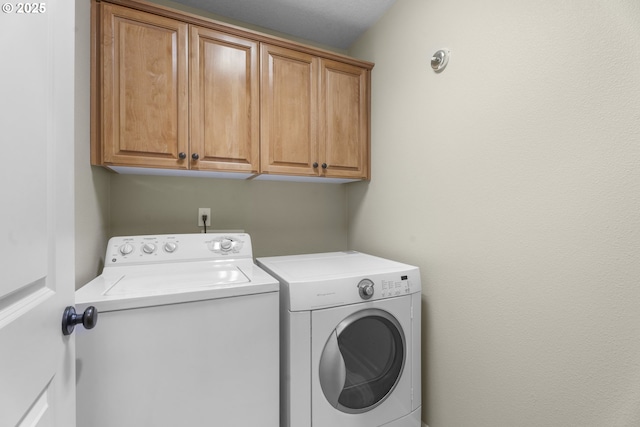 laundry room featuring cabinets and washing machine and dryer