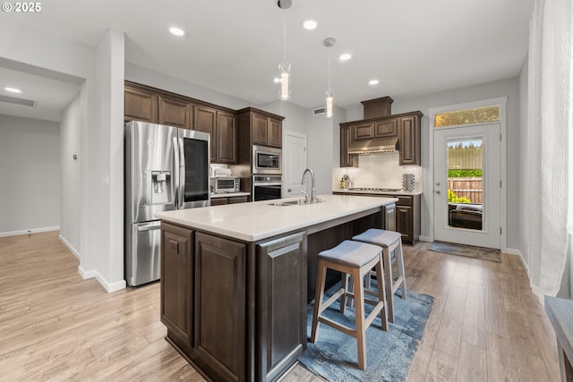 9414 NE 166th Ave, Vancouver, WA 98682 - kitchen with appliances with stainless steel finishes, a sink, dark brown cabinetry, under cabinet range hood, and light countertops