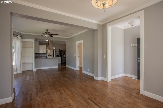 unfurnished living room featuring dark wood finished floors, baseboards, ornamental molding, a chandelier, and ceiling fan