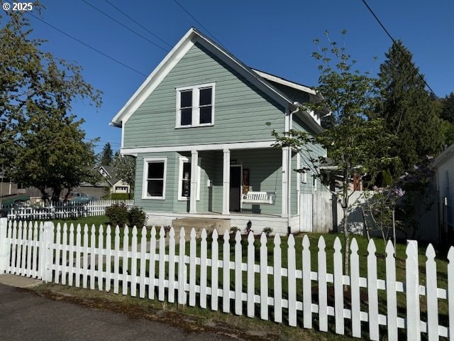view of front facade featuring covered porch and a fenced front yard