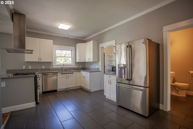 kitchen with stainless steel appliances, island range hood, a sink, ornamental molding, and white cabinetry