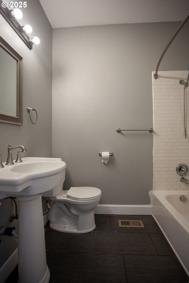 full bathroom with tile patterned flooring, toilet, bathtub / shower combination, and baseboards