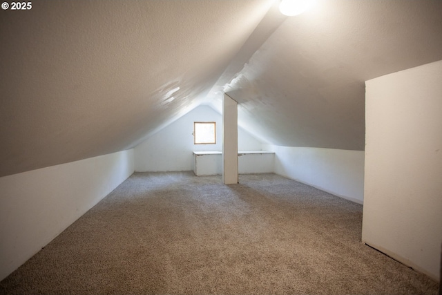 bonus room featuring vaulted ceiling and carpet flooring