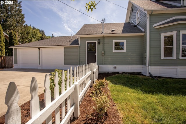 view of front of home with a garage, concrete driveway, and roof with shingles