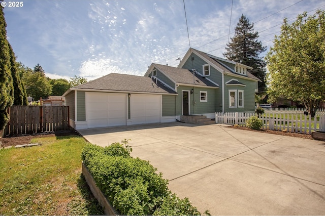 view of front of house with driveway, an attached garage, and fence