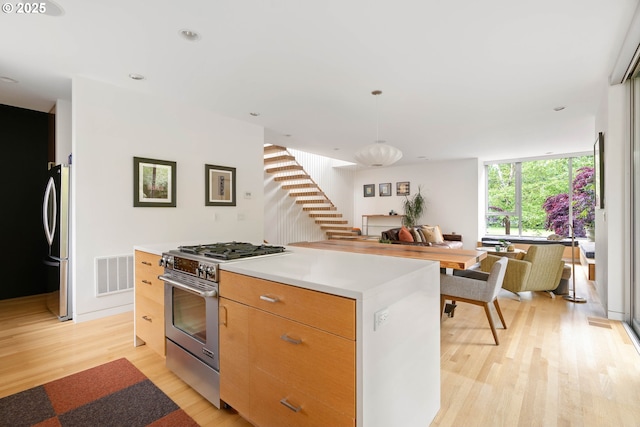 435 N Shaver St, Portland, OR 97227 - kitchen featuring appliances with stainless steel finishes, light wood-type flooring, open floor plan, a center island, and modern cabinets