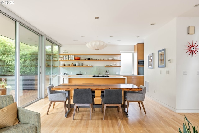 435 N Shaver St, Portland, OR 97227 - dining space with light wood-type flooring, wet bar, floor to ceiling windows, and baseboards