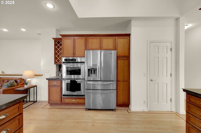 2915 Chandler Ave, Eugene, OR 97403 - kitchen with stainless steel appliances, dark countertops, light wood-type flooring, brown cabinetry, and recessed lighting