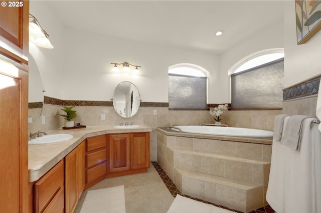 full bath featuring tile patterned flooring, double vanity, a sink, and a bath