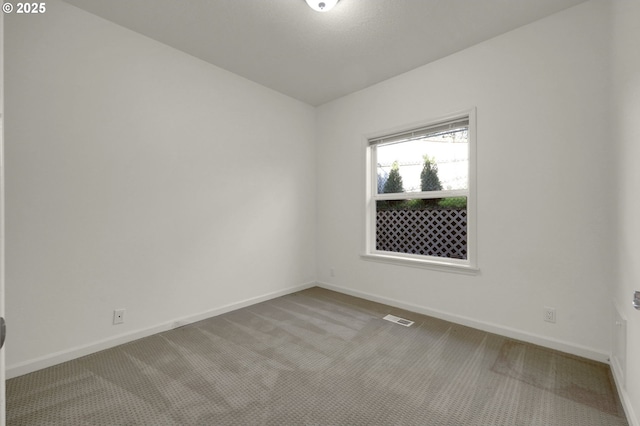 unfurnished room featuring carpet floors, visible vents, and baseboards