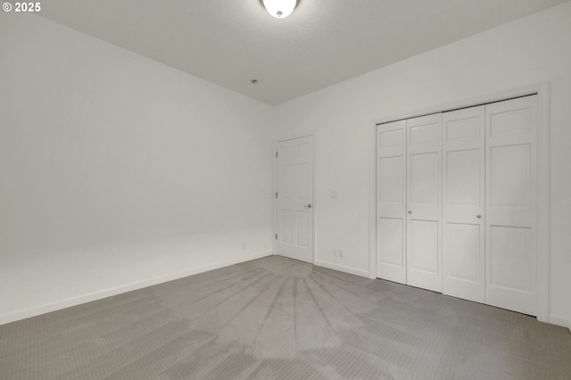 unfurnished bedroom featuring a closet, carpet flooring, and baseboards