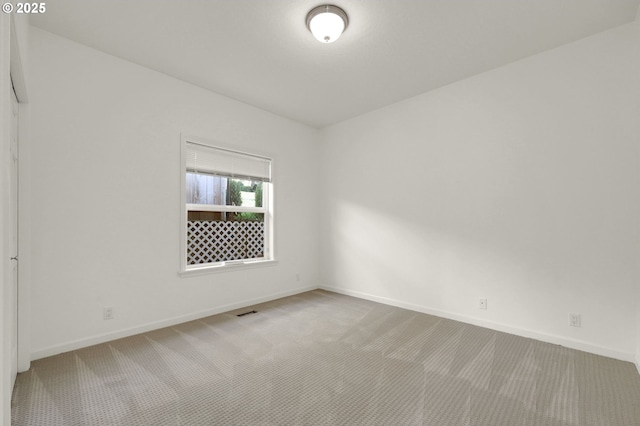 carpeted empty room with visible vents and baseboards