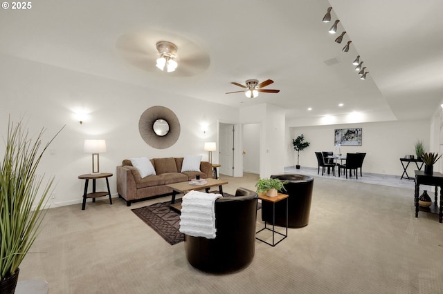 living area with a ceiling fan, rail lighting, light carpet, and baseboards