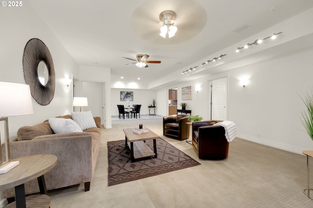 living area featuring a ceiling fan, light colored carpet, and baseboards