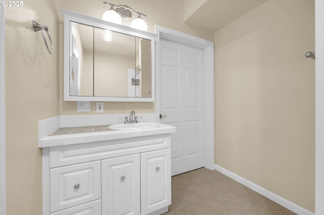 bathroom with tile patterned flooring, vanity, and baseboards