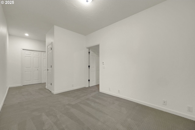 interior space with recessed lighting, a closet, light carpet, and baseboards