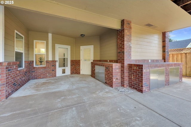 view of patio with fence and visible vents