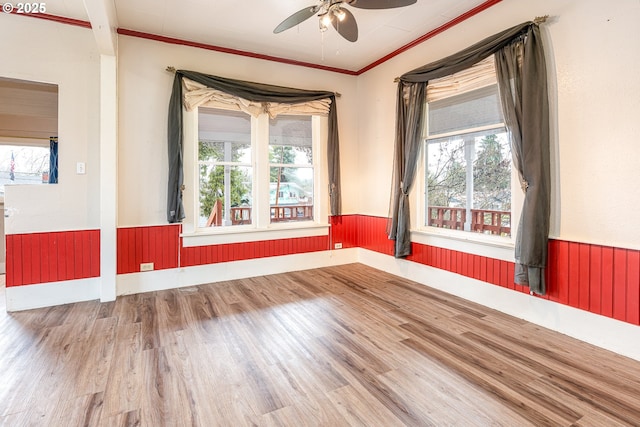 unfurnished room with plenty of natural light and wainscoting