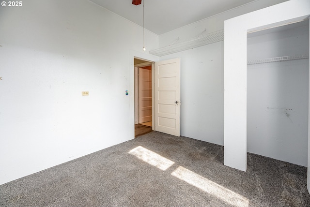 unfurnished bedroom with a ceiling fan, carpet, and a closet