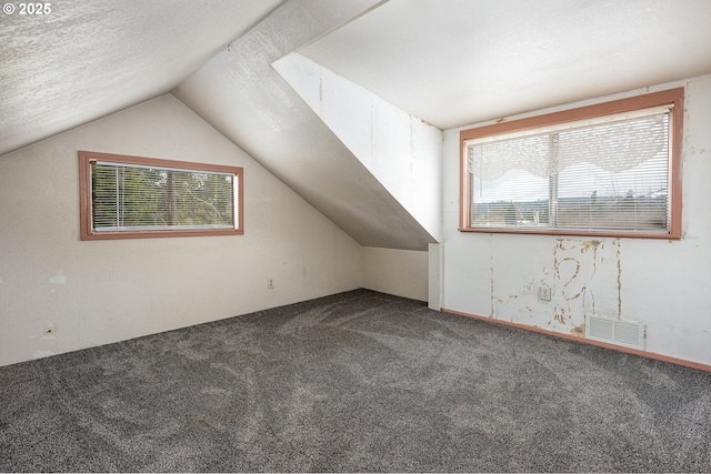 bonus room with vaulted ceiling, visible vents, carpet floors, and a textured ceiling