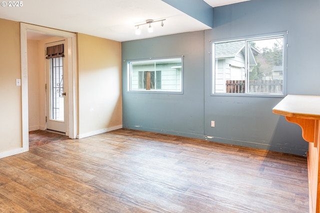 unfurnished room with baseboards and wood finished floors