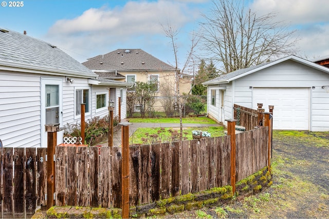 view of yard featuring an outbuilding, a garage, and fence