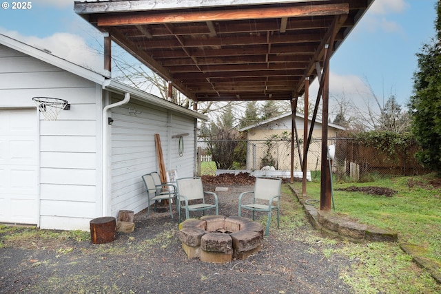 view of yard featuring fence, a garage, and an outdoor fire pit