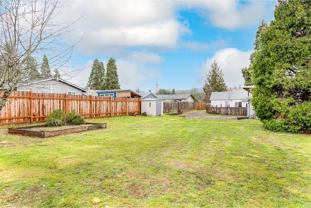 view of yard featuring an outbuilding, a storage unit, and a fenced backyard