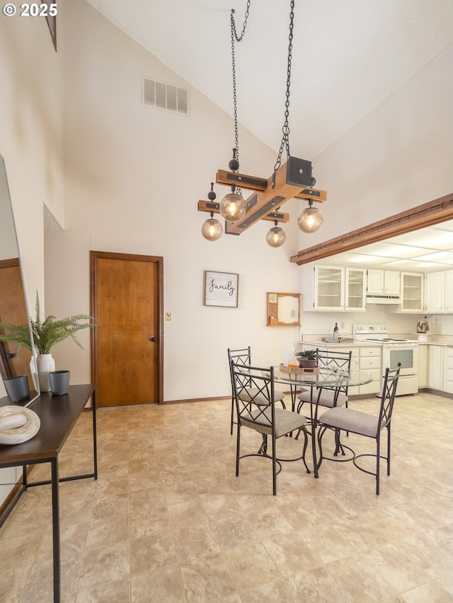 dining room featuring high vaulted ceiling