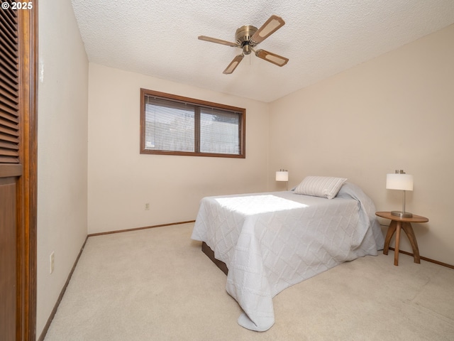 carpeted bedroom featuring a textured ceiling and ceiling fan