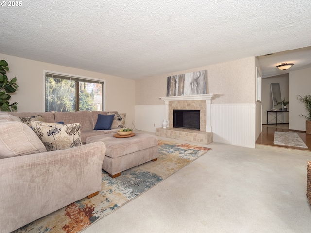 carpeted living room featuring a fireplace and a textured ceiling