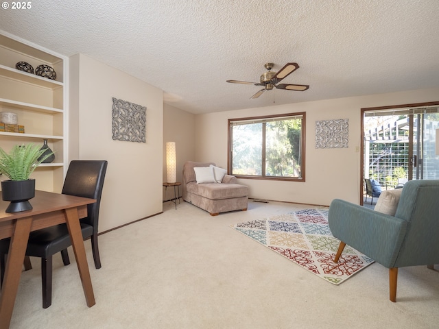 carpeted living room with ceiling fan and a textured ceiling