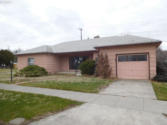 ranch-style home with a garage, concrete driveway, and a front yard