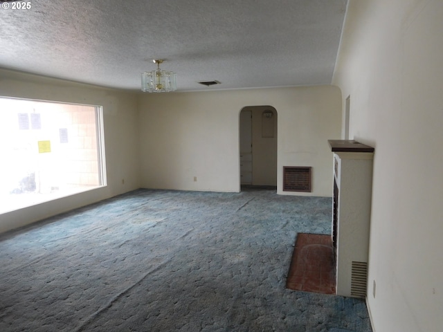 unfurnished living room featuring carpet floors and a textured ceiling