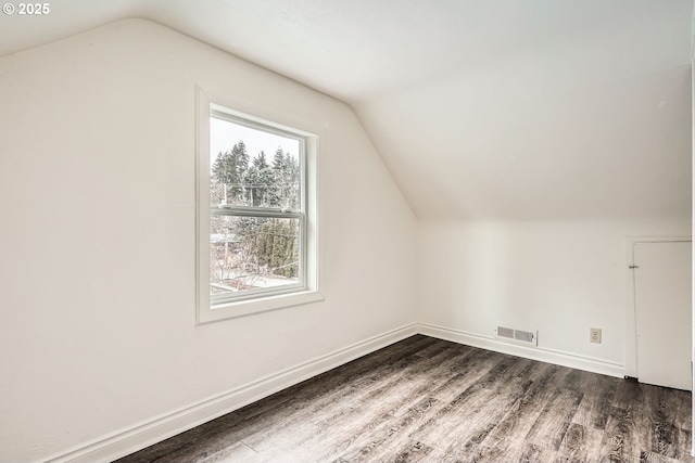 bonus room featuring dark wood-style floors, vaulted ceiling, visible vents, and baseboards