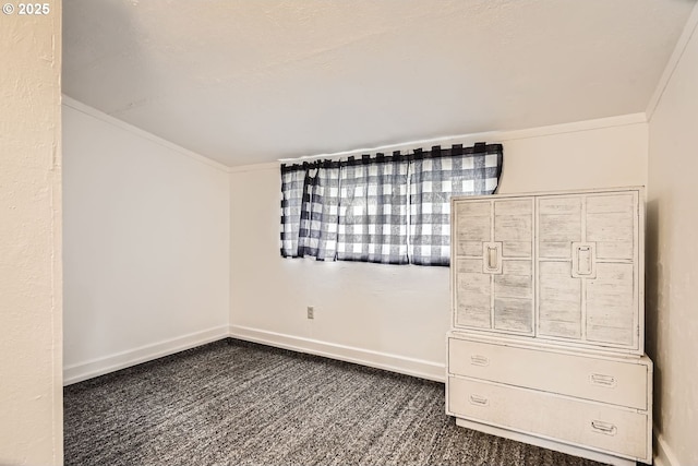 unfurnished bedroom with baseboards, dark carpet, and crown molding