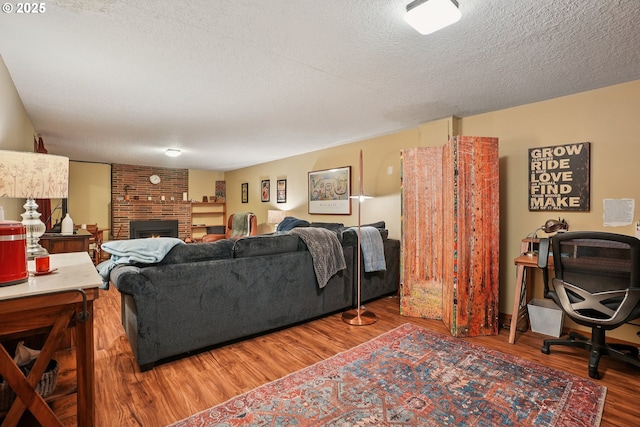 2235 SE 185th Ave, Portland, OR 97233 - living area featuring wood finished floors, a brick fireplace, and a textured ceiling