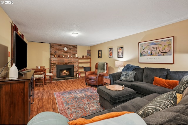 2235 SE 185th Ave, Portland, OR 97233 - living room featuring wood finished floors, a brick fireplace, and a textured ceiling
